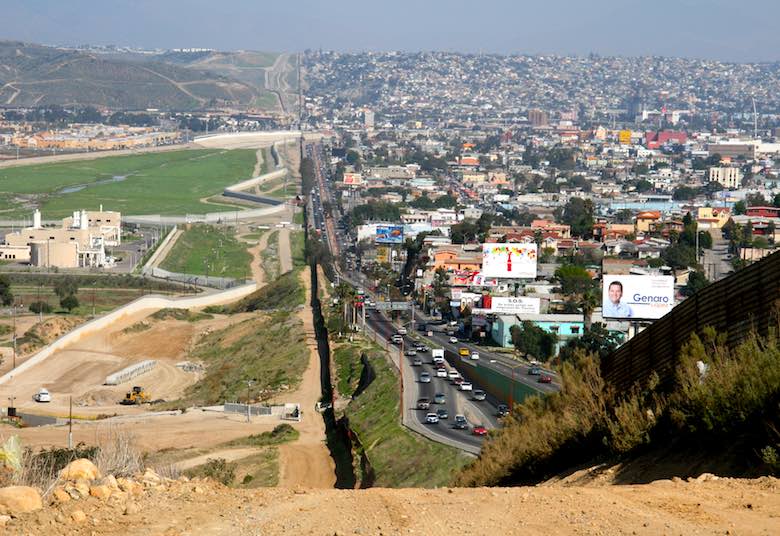 A small fence separates densely populated Tijuana, Mexico, right, from the United States in the Border Patrolâ€™s San Diego Sector.  Construction is underway to extend a secondary fence over the top of this hill and eventually to the Pacific Ocean.